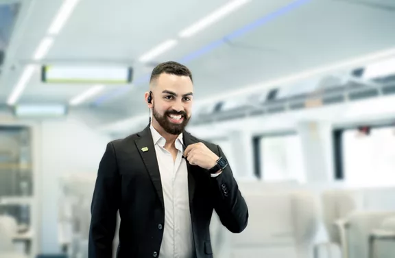 A smiling Brightline team member walking through a Brightline train