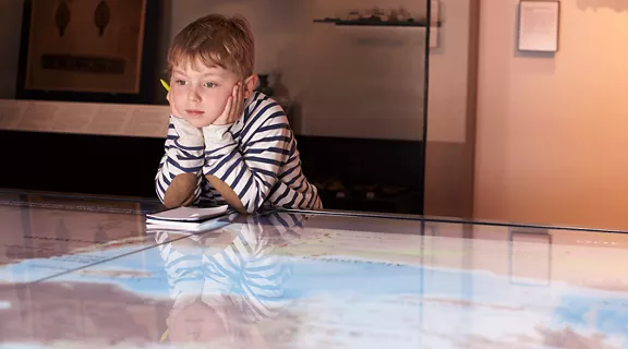 A child at a museum watching an educational video presentation 