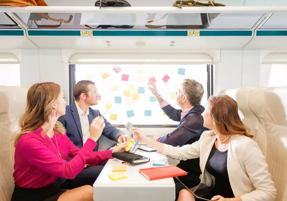 Business team working with sticky notes on the train window, aboard Brightline train