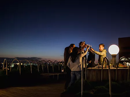 Group of friends having a rooftop party after dark.