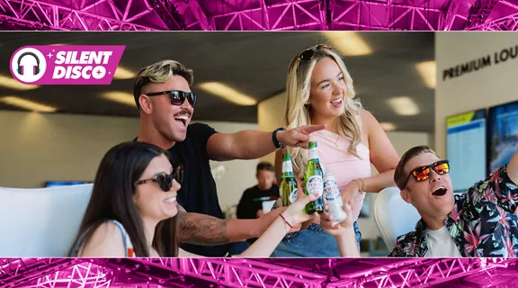 A group of friends cheering and enjoying drinks in the Brightline train station on their way to ULTRA Music Festival.