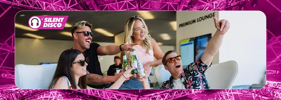 Four friends cheering and enjoying drinks together at ULTRA Music Festival.