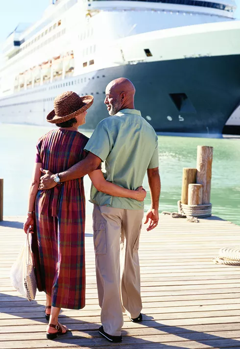 couple on dock standing in front of cruise ship