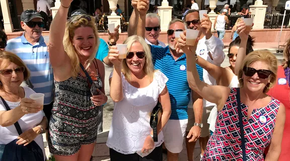 A group of men and women posing with drinks during a West Palm Beach Food Tour.