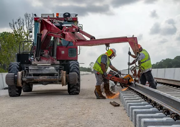 A group of Brightline teammates working on a section of the railroad tracks.