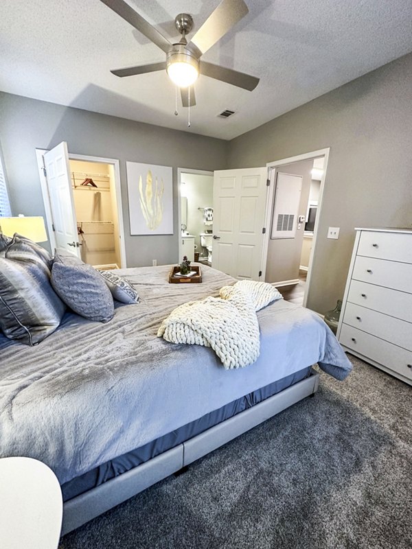 Cozy bedroom with modern decor at Avana Long Point Apartments featuring plush bedding and natural light