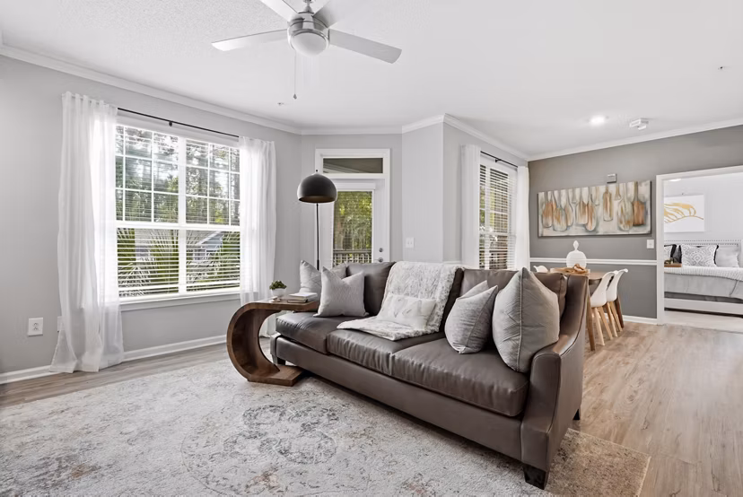 Living room with modern furniture and large windows at Avana Long Point Apartments