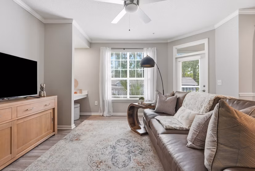 Inviting living room with modern decor and large windows at Avana Long Point Apartments