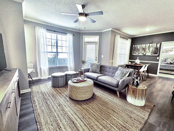Inviting living room with modern decor and large windows at Avana Long Point Apartments