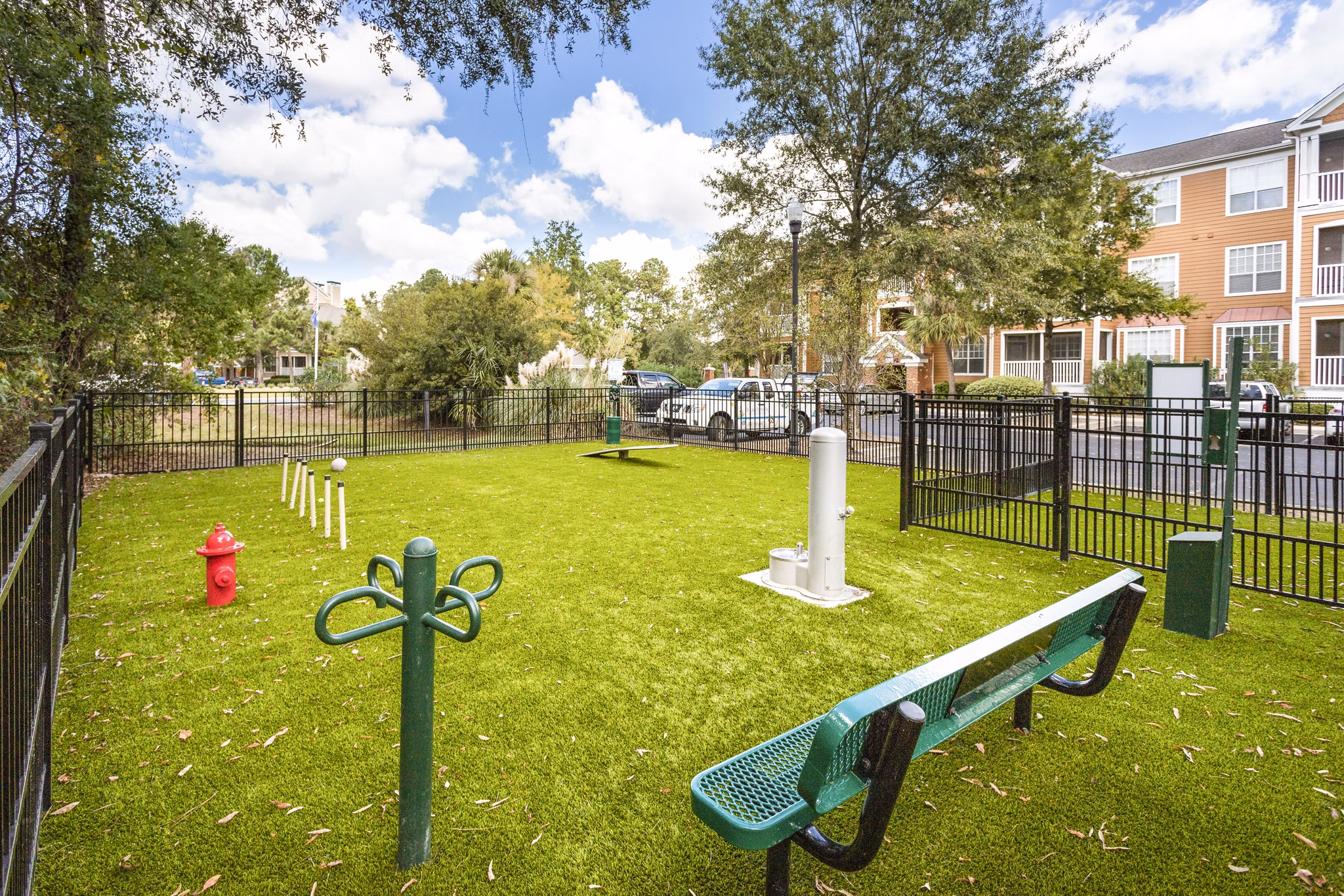 Shaded dog park with agility equipment at Avana Long Point Apartments, perfect for pet-friendly living and outdoor pet activities