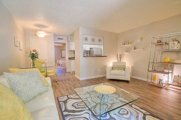 Bright living room with cozy seating and large windows at Eagle Point Apartments