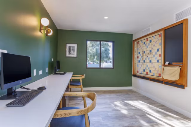 Modern business center with workstations and conference table at Avana Tempe Apartments