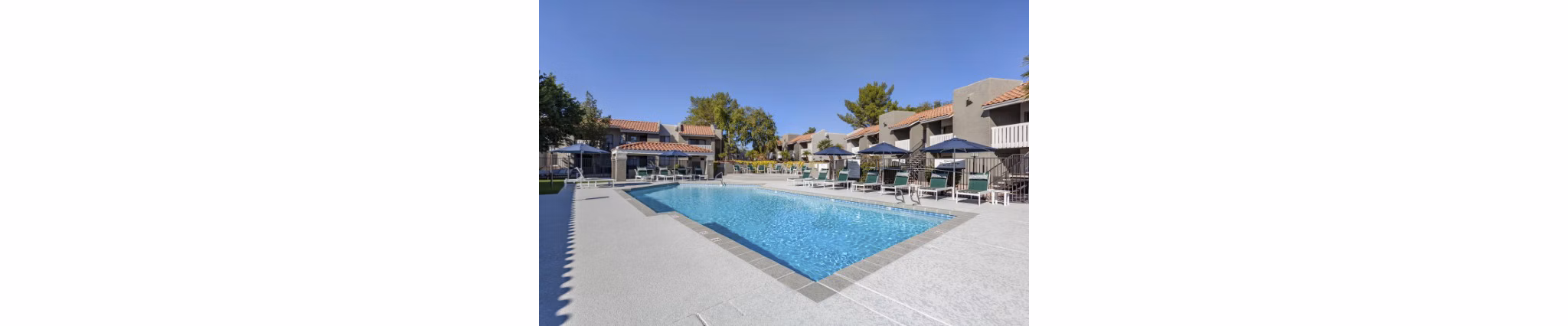 Luxurious pool area at Avana Tempe Apartments with sun loungers and lush greenery, offering a perfect relaxation spot for residents
