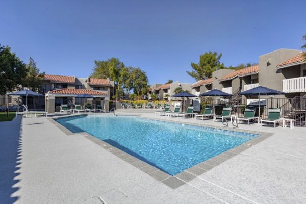 Luxurious pool area at Avana Tempe Apartments with sun loungers and lush greenery, offering a perfect relaxation spot for residents