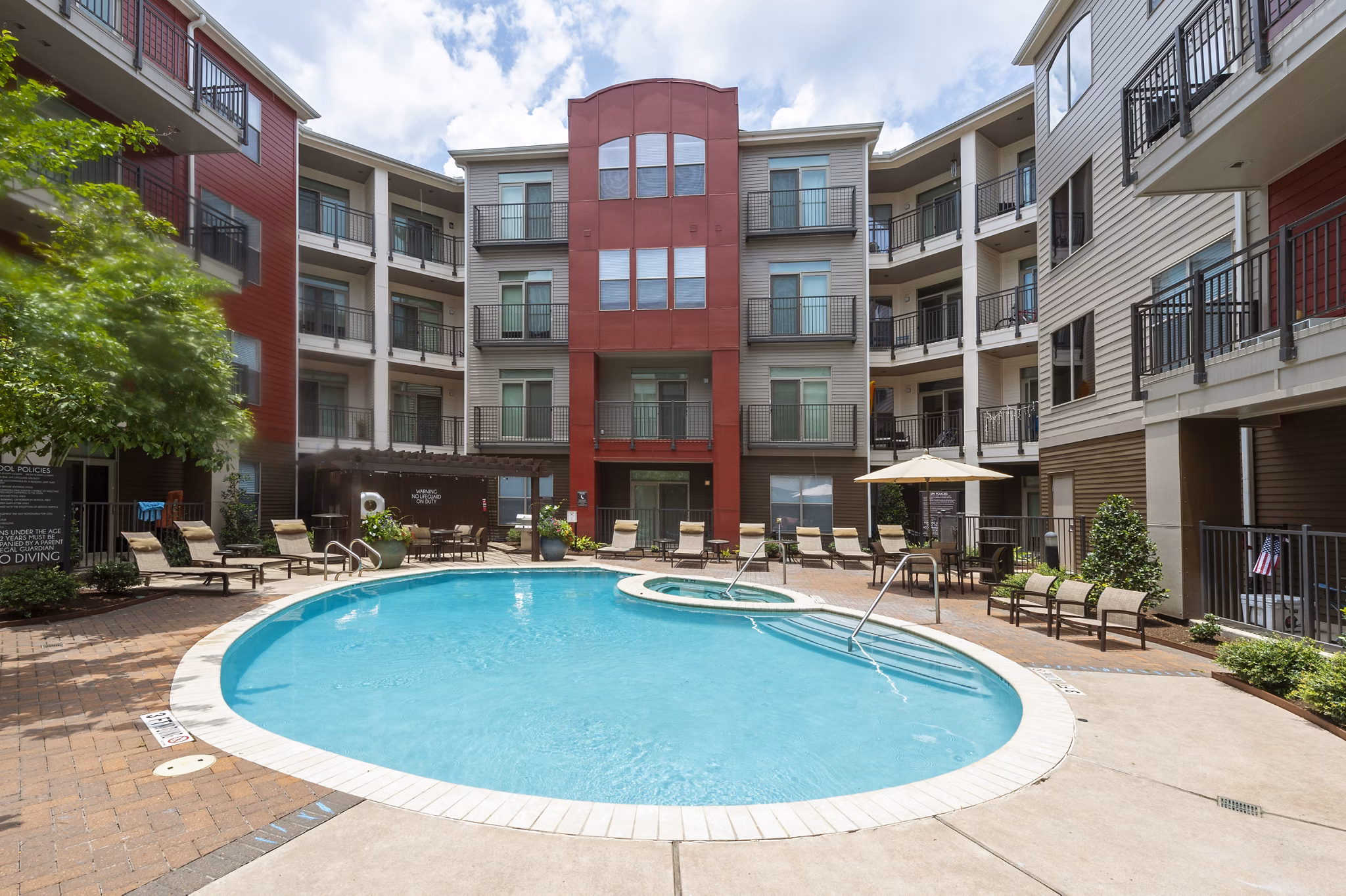 Resort-style pool at Boardwalk at Town Center Apartments, featuring lounge chairs and landscaped surroundings