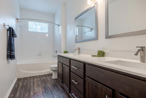 Modern bathroom with elegant vanity and large mirror at The Preserve at Travis Creek Apartments