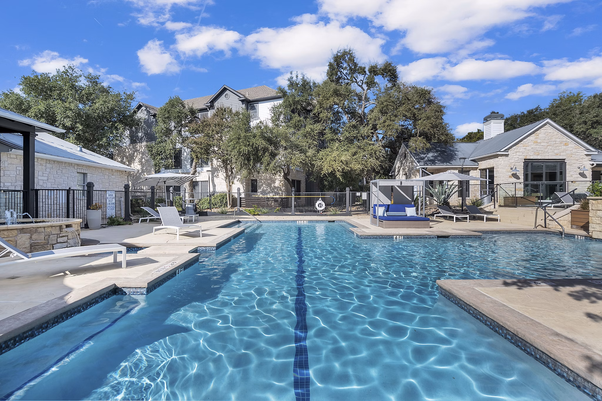 Relaxing pool with sun loungers at The Preserve at Travis Creek Apartments, offering serene outdoor spaces in Austin luxury living