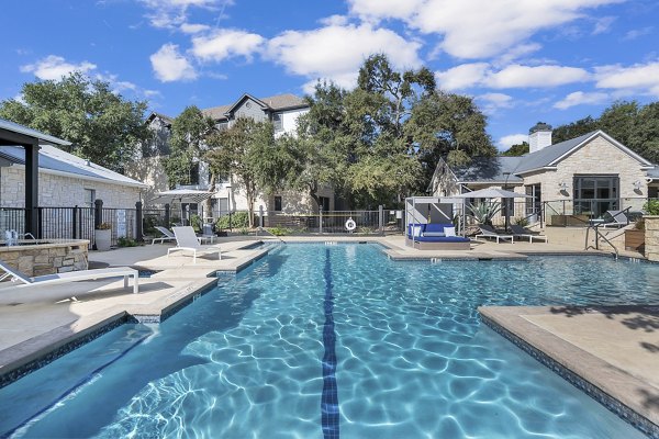 Relaxing pool with sun loungers at The Preserve at Travis Creek Apartments, offering serene outdoor spaces in Austin luxury living