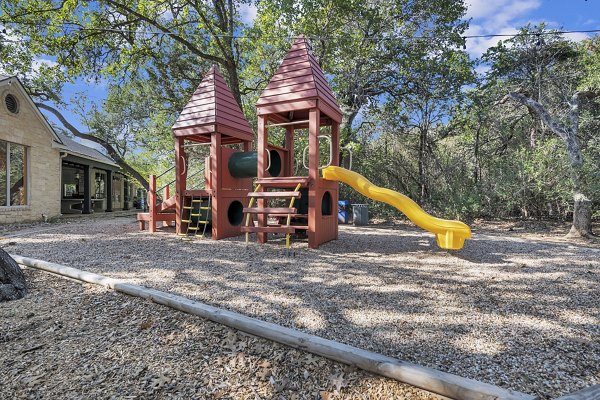 Playground with modern equipment at The Preserve at Travis Creek Apartments, designed for family-friendly recreation and luxury living