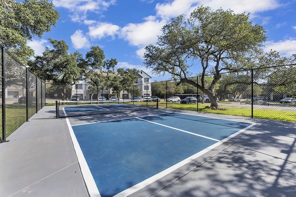 Outdoor sport court with basketball hoops at The Preserve at Travis Creek Apartments, perfect for active lifestyles and recreation in a luxury setting