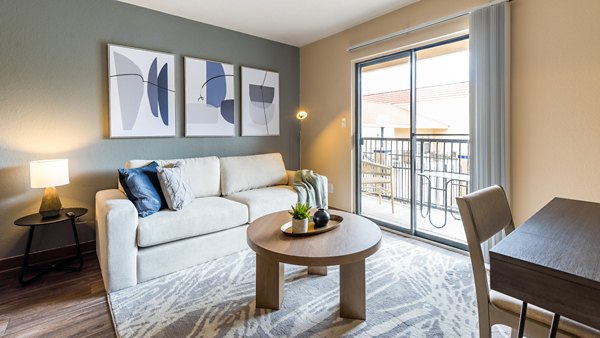 Spacious living room with modern design elements in Odyssey Landing Apartments