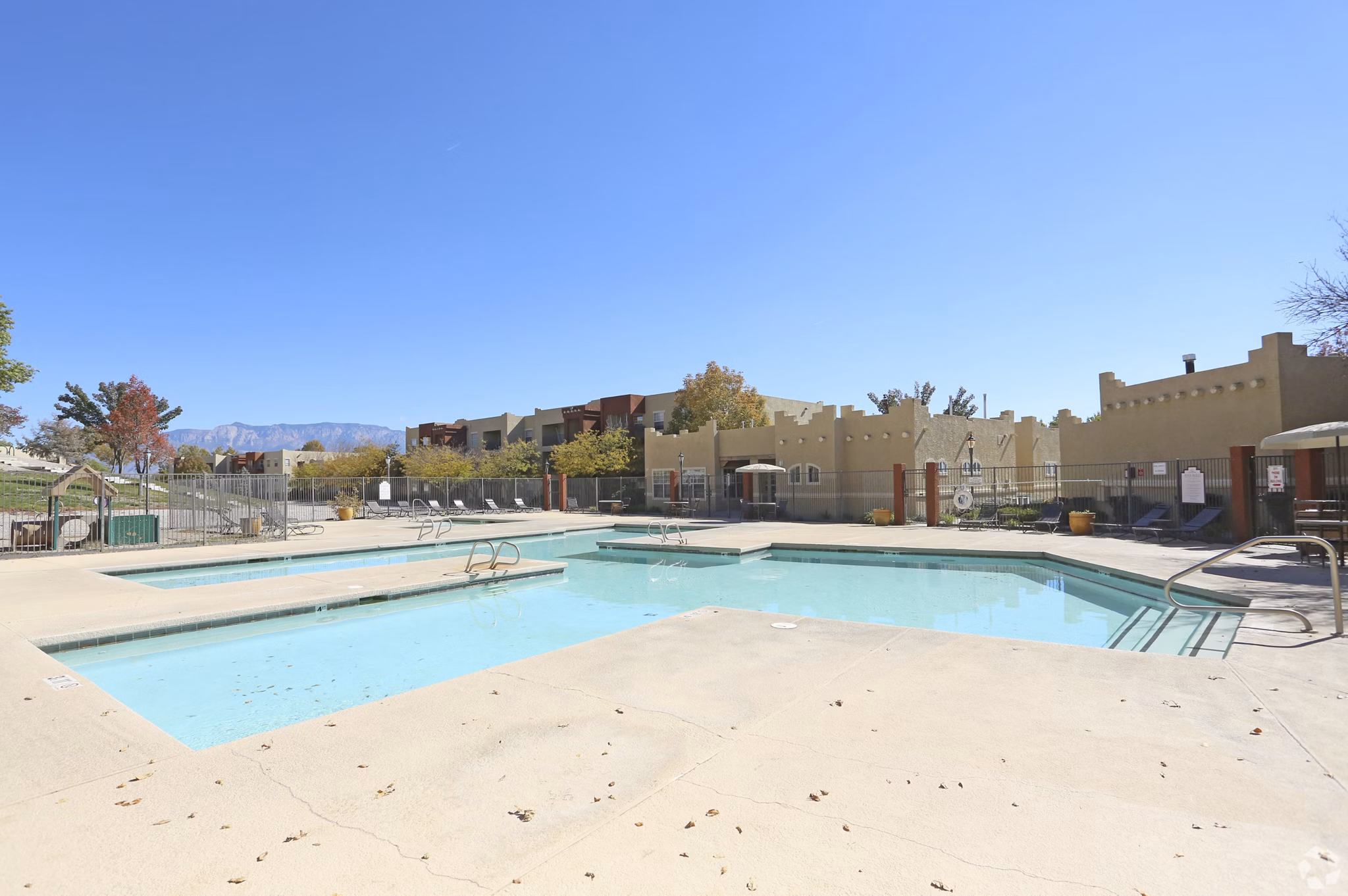 Inviting outdoor pool with lounge chairs at Odyssey Landing Apartments offering luxury leisure living