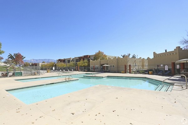 Inviting outdoor pool with lounge chairs at Odyssey Landing Apartments offering luxury leisure living