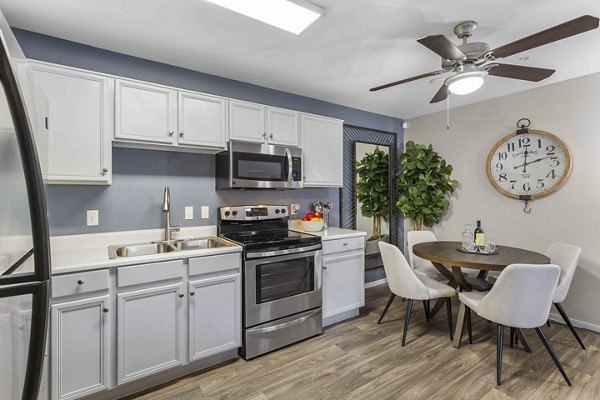 Modern kitchen with granite countertops and stainless steel appliances in Destinations Pebble Apartments