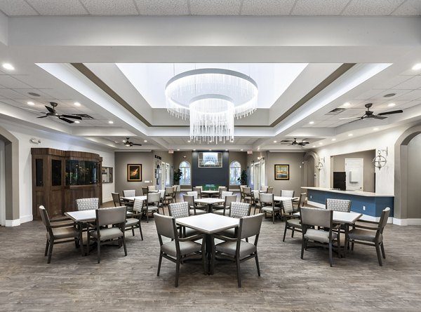 Modern dining area with tables, chairs, and a chandelier at luxury apartments