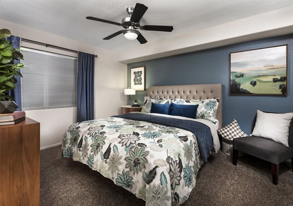 Bedroom with cozy decor and large windows at Destinations Spring Valley Apartment Homes