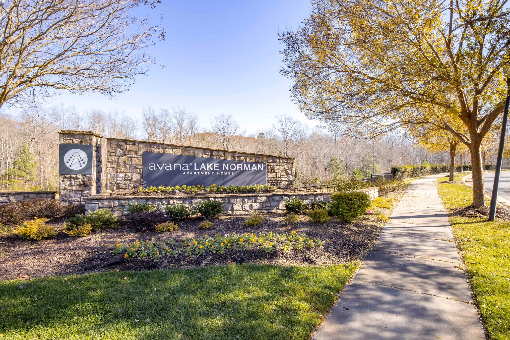 Avana Lake Norman Apartments: Modern signage amidst lush landscapes