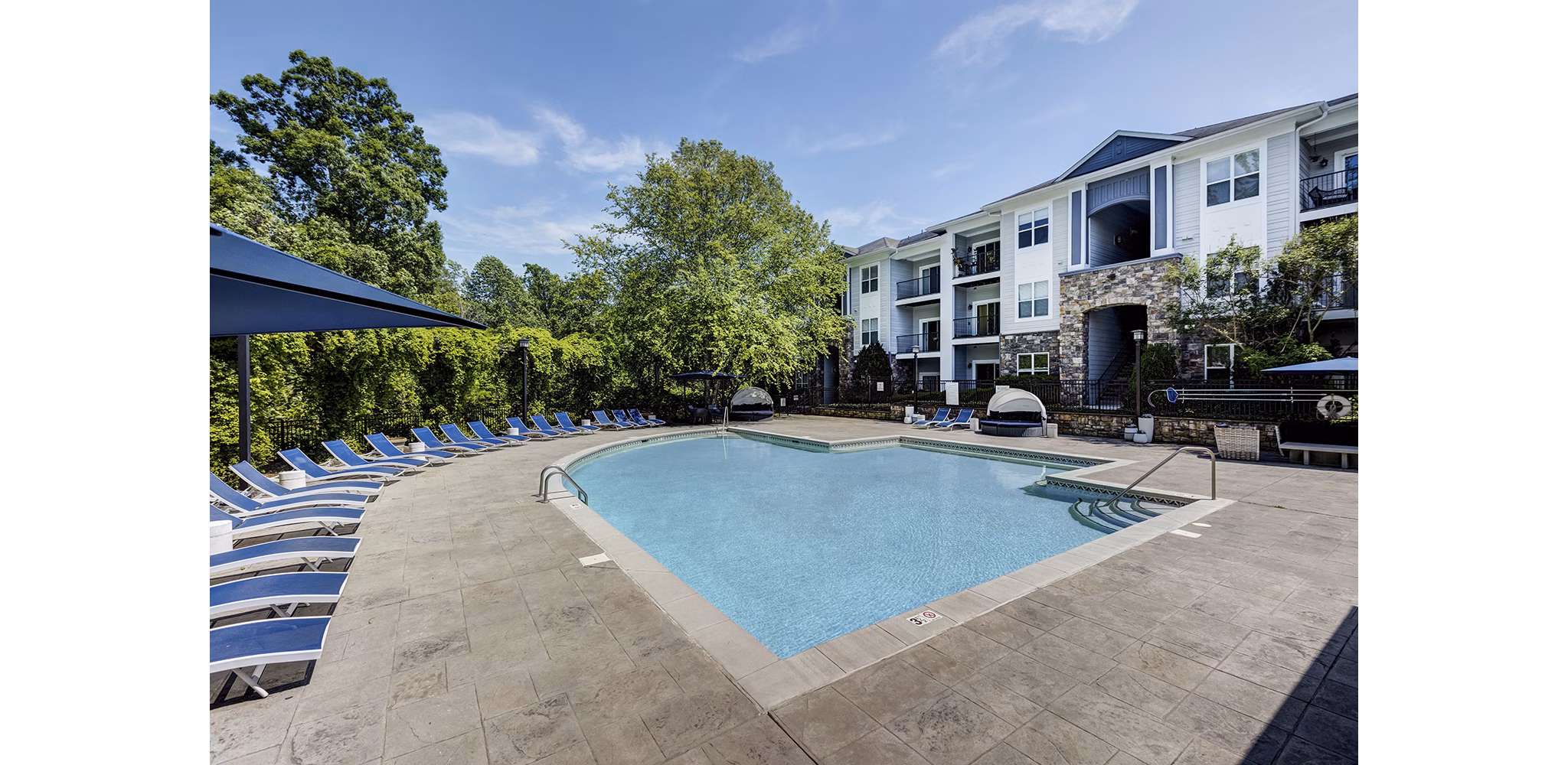 Outdoor swimming pool at Avana Lake Norman Apartments with lounge chairs and landscaping