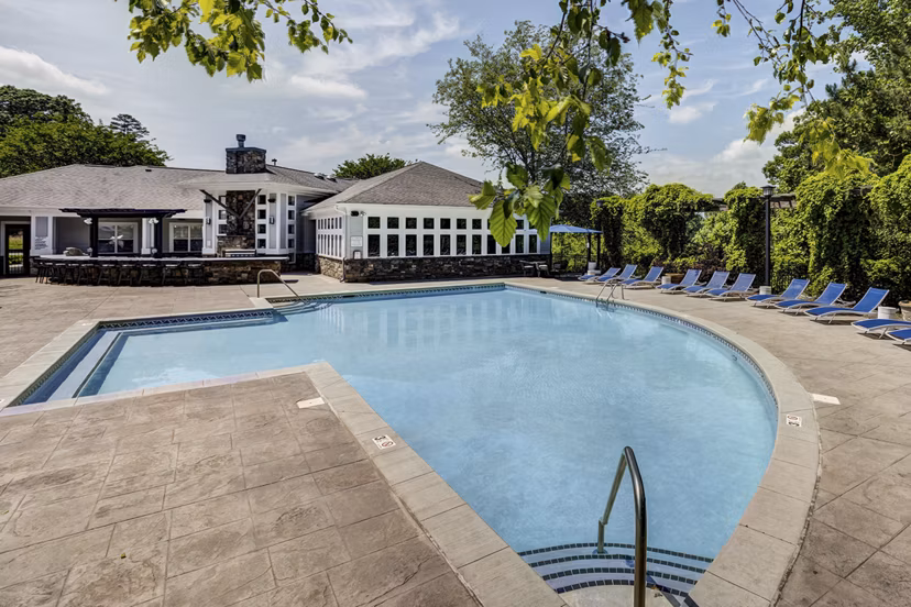Resort-style swimming pool with lounge chairs at Avana Lake Norman Apartments offering luxury living amenities