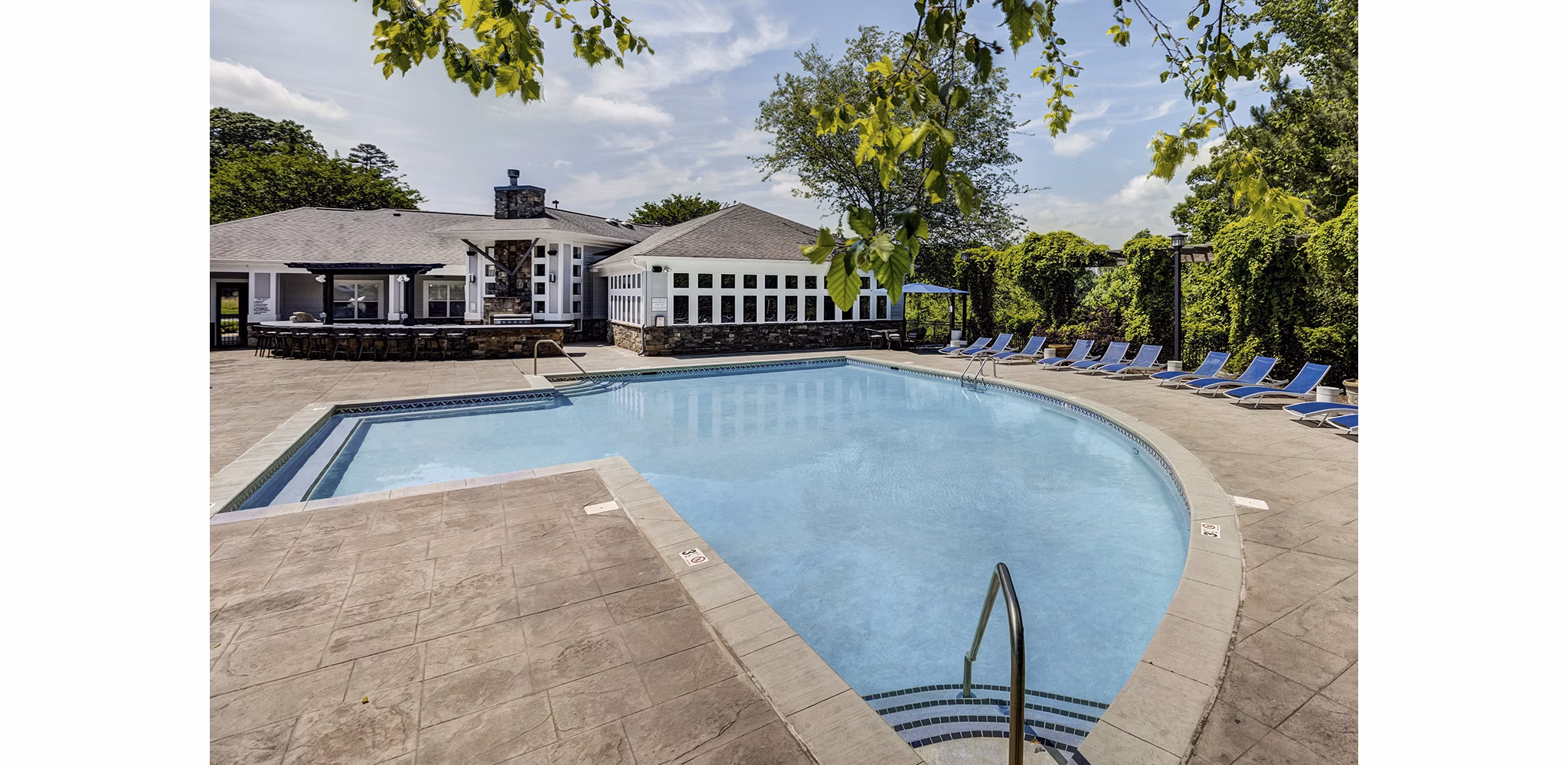 Resort-style swimming pool with lounge chairs at Avana Lake Norman Apartments offering luxury living amenities