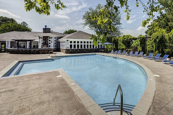 Resort-style swimming pool with lounge chairs at Avana Lake Norman Apartments offering luxury living amenities