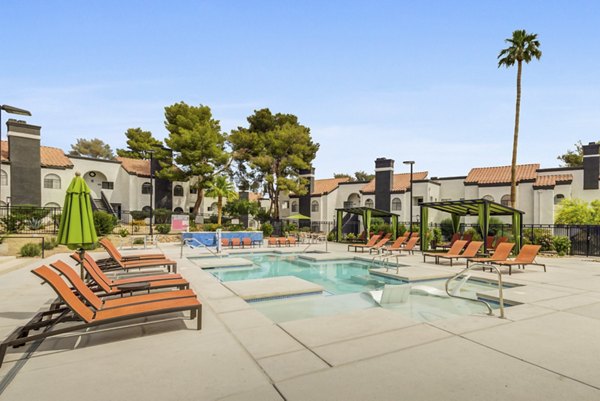 Relaxing poolside area at Bay Court at Montego Bay Apartments with lush landscaping and lounge seating