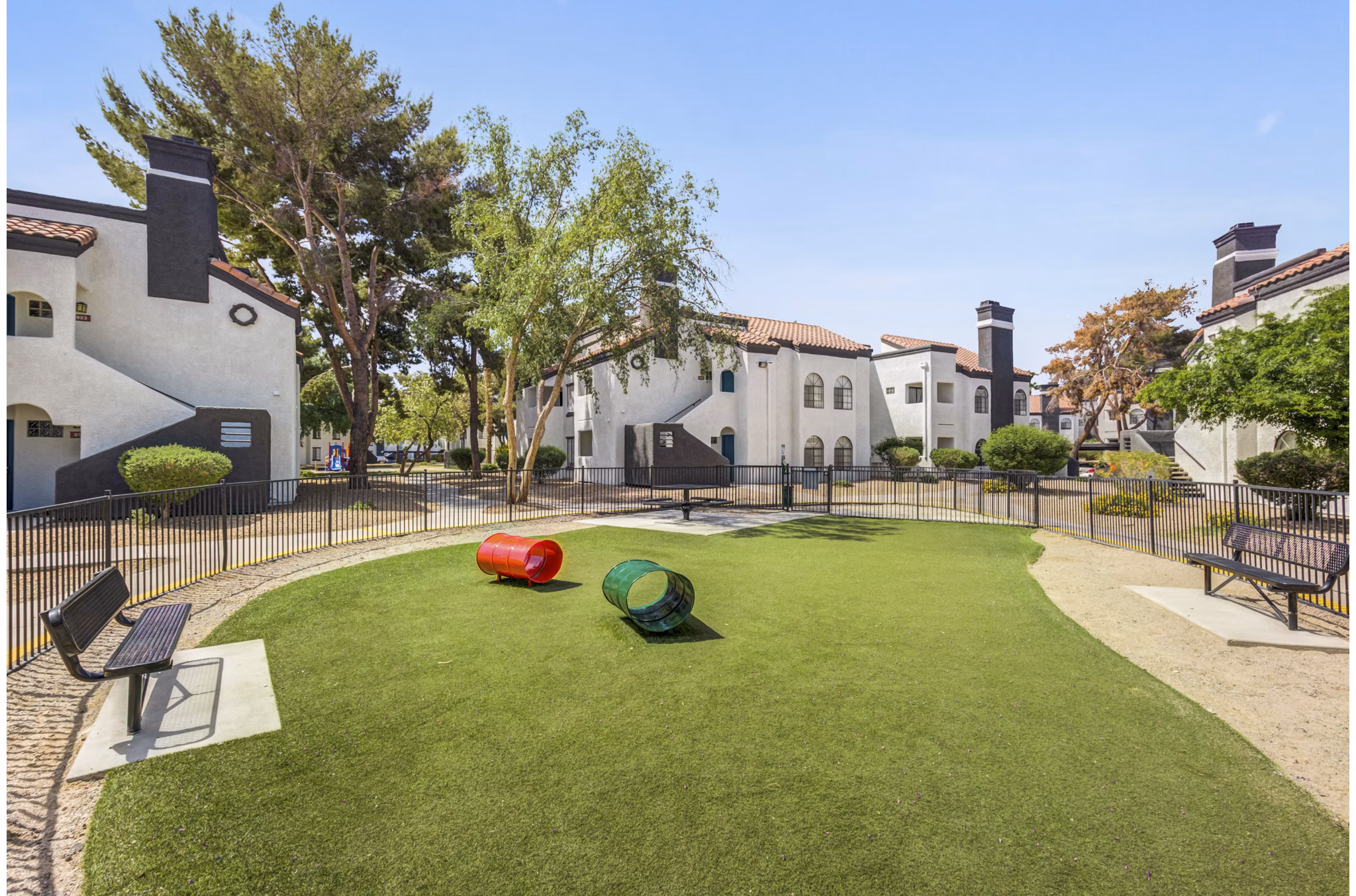 Spacious dog park at Montego Bay Apartments featuring agility course and seating areas for residents
