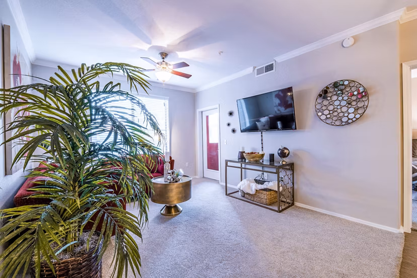 Modern living room with elegant furnishings and large windows at Alanza Place Apartments