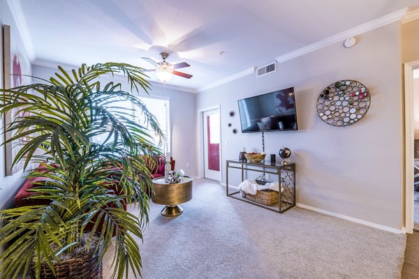 Modern living room with elegant furnishings and large windows at Alanza Place Apartments