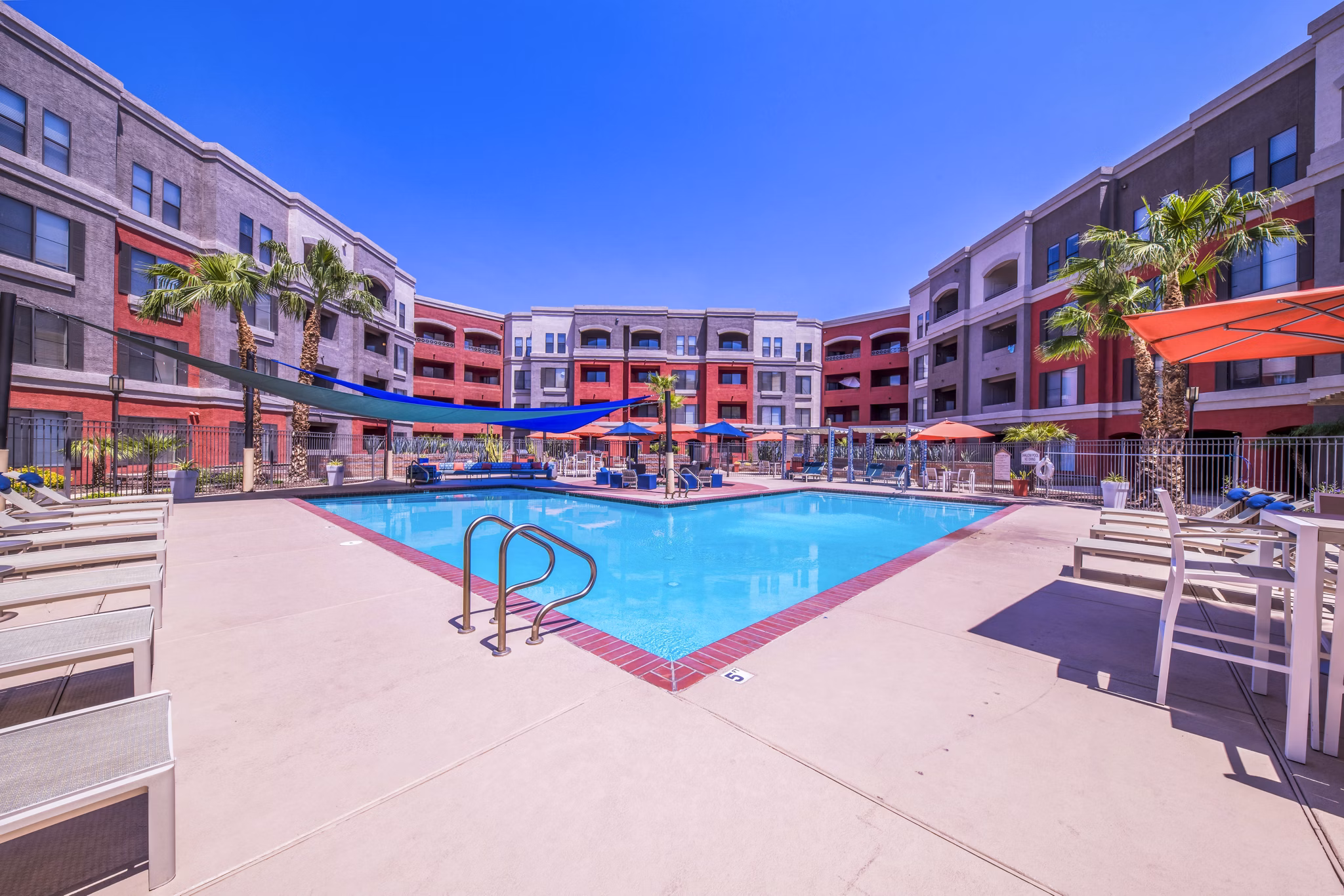 Resort-style pool area with loungers at Alanza Place Apartments, a Greystar luxury community