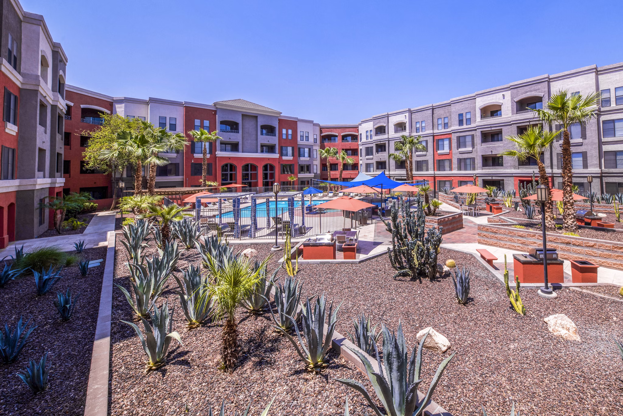 Tranquil poolside with lush greenery at Alanza Place Apartments, perfect for relaxation and social gatherings