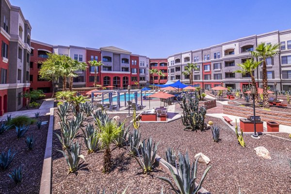 Tranquil poolside with lush greenery at Alanza Place Apartments, perfect for relaxation and social gatherings