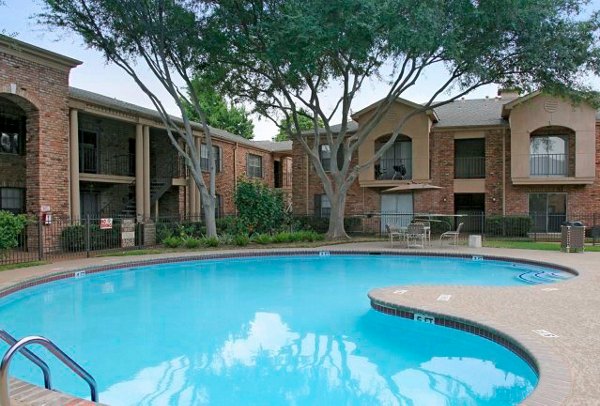 Resort-style pool at Sendera at Greenway Apartments featuring spacious sundeck and lush landscaping