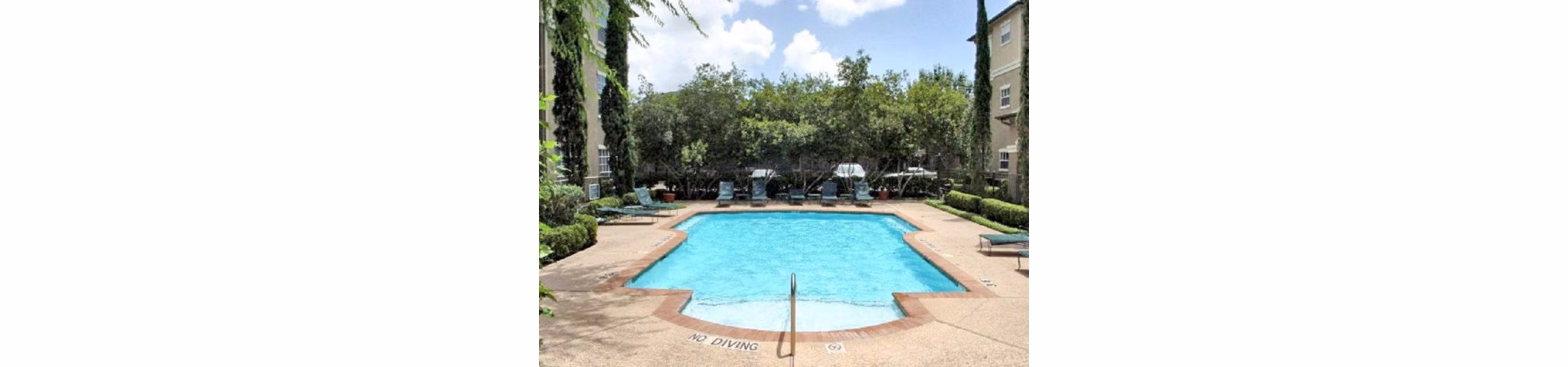 Luxurious pool area at The Boulevard Apartments with comfortable lounge seating and stylish landscaping