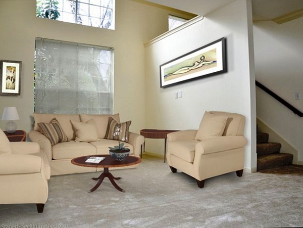 Comfortable living room featuring modern decor and large windows at Plaza at River Oaks Apartments