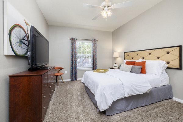 Contemporary bedroom featuring a plush bed and modern decor at Clear Creek Meadows Apartments