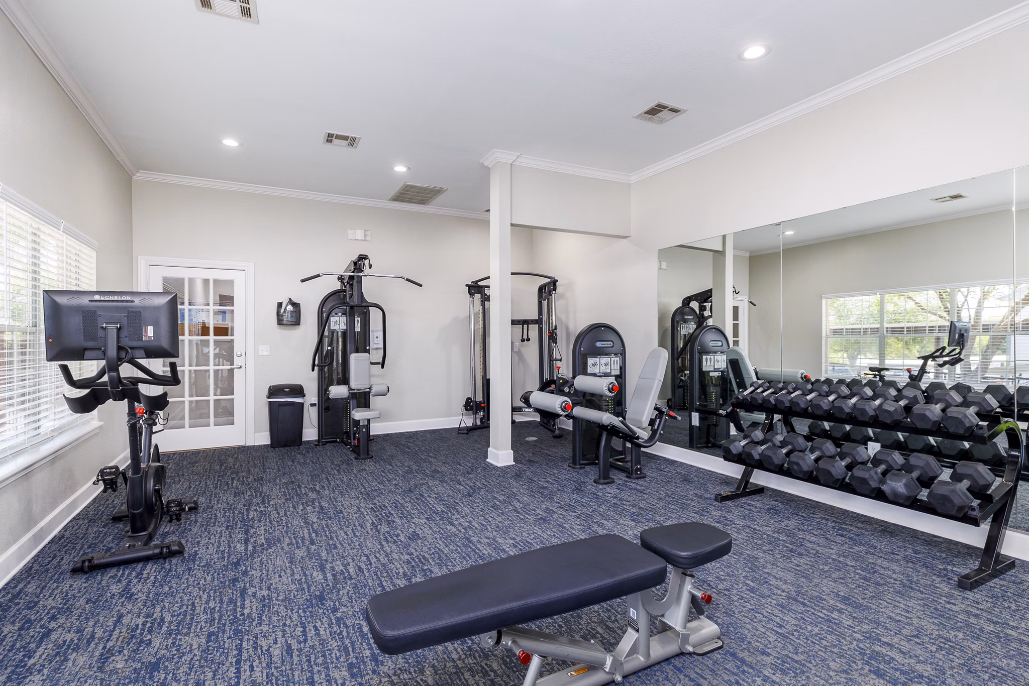 Modern fitness center at Clear Creek Meadows Apartments with advanced equipment and spacious workout areas