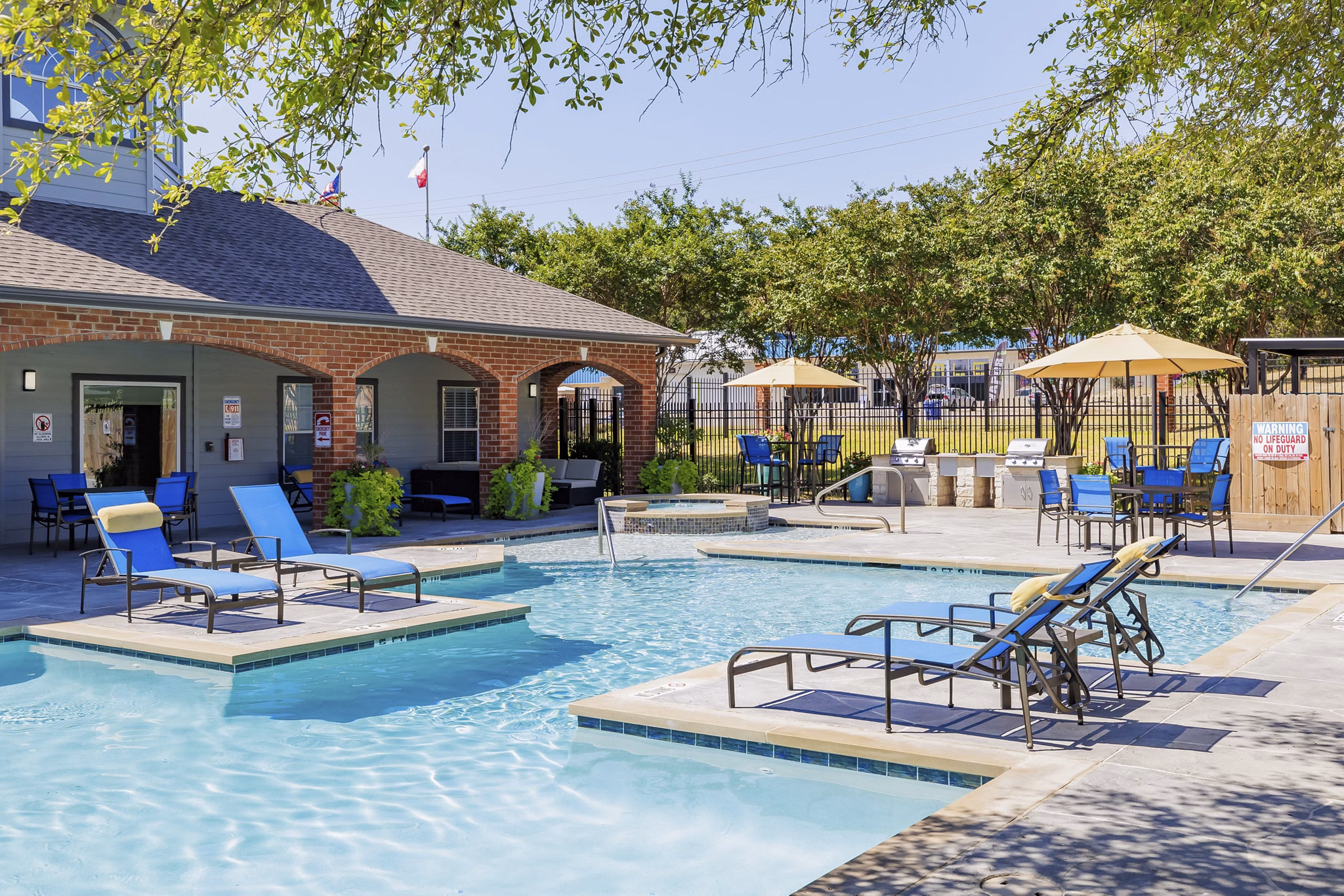 Resort-style pool surrounded by lush greenery at Clear Creek Meadows Apartments