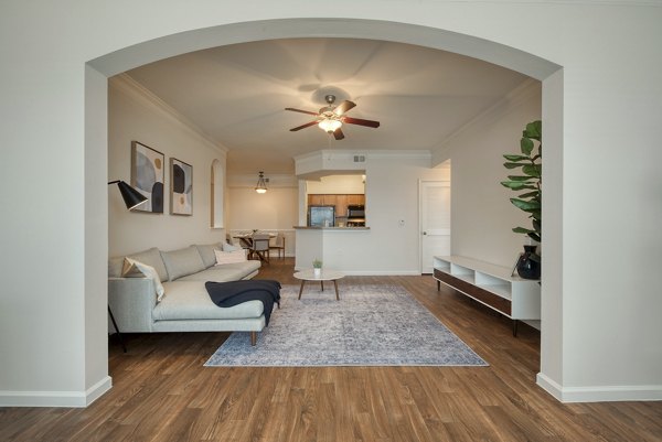 Living room with contemporary decor and large windows at South Bay Apartments, a luxury living space offered by Greystar