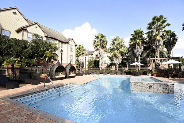 Resort-style pool at Avana Sugar Land Apartments with sun loungers and landscaped surroundings